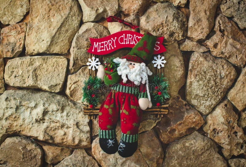 Santa clause Christmas decoration made with knitted wool hanging on a stone wall background. Santa clause Christmas decoration made with knitted wool hanging on royalty free stock images